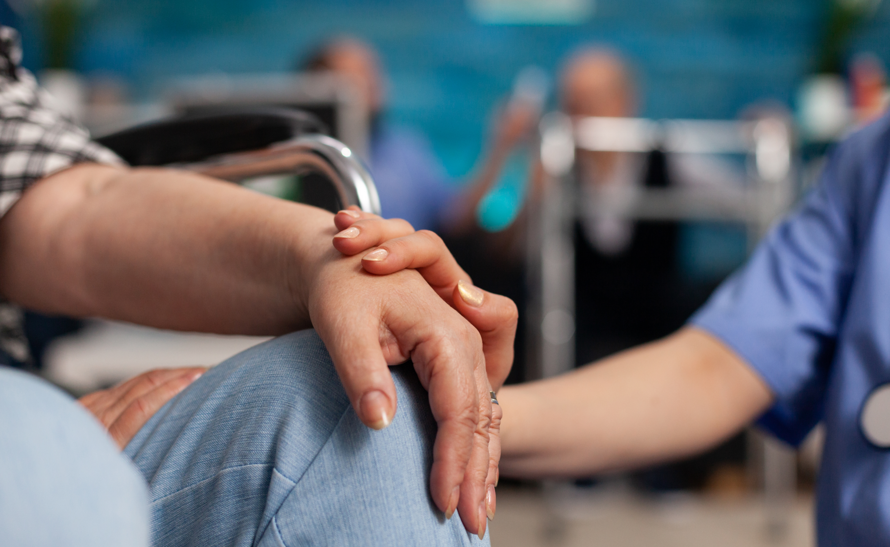 Caregiver holding elderly person hand